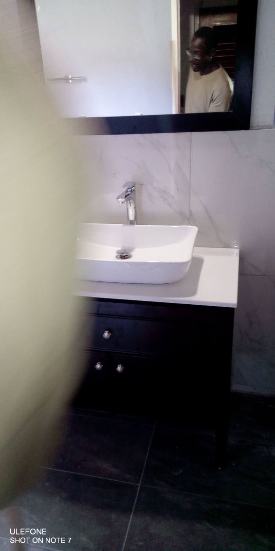 White vessel sink on a dark cabinet with a chrome faucet