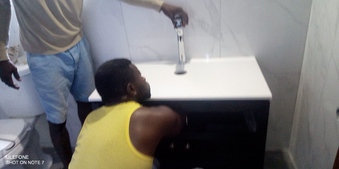 On Time crew installing a bathroom vanity with a chrome faucet